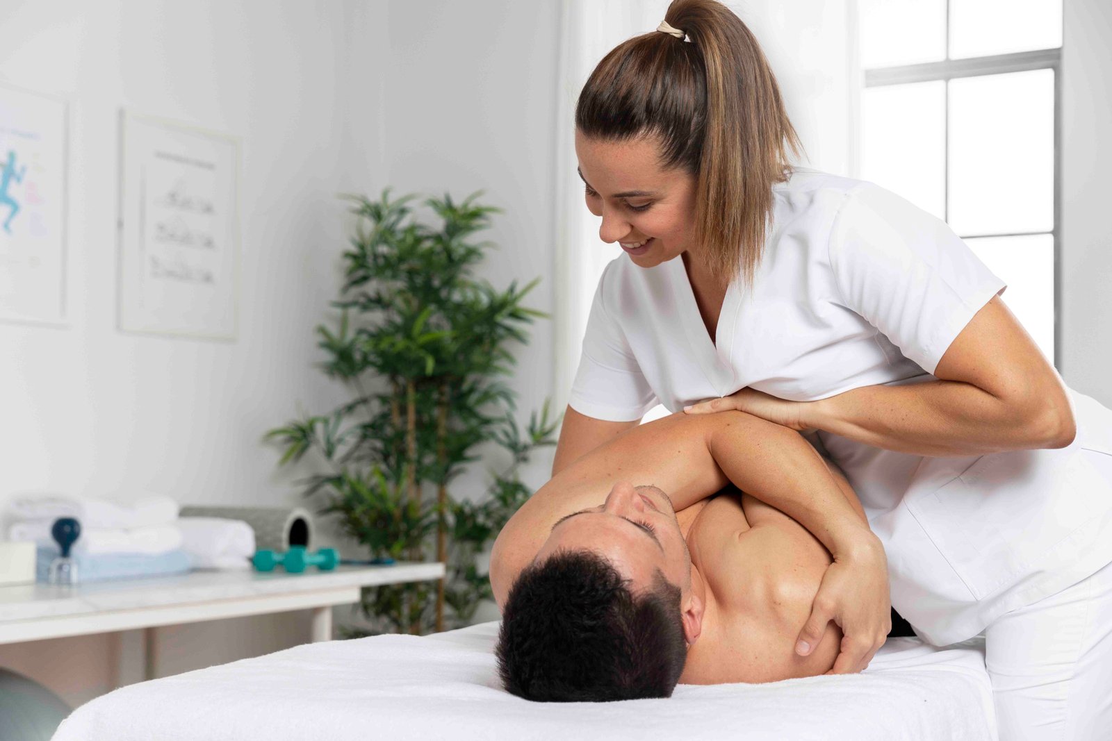 Female therapist massaging male client's neck and shoulders